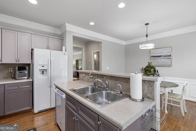 kitchen with dishwasher, an island with sink, sink, hanging light fixtures, and white refrigerator with ice dispenser