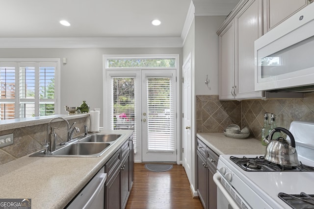 kitchen with dark hardwood / wood-style floors, tasteful backsplash, sink, ornamental molding, and white appliances