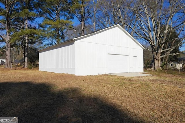 view of outdoor structure with a garage and a lawn