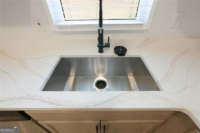 details featuring light stone counters and sink