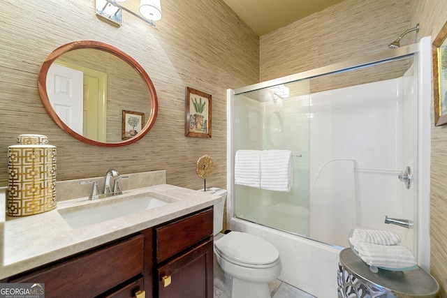 full bathroom with vanity, wooden walls, shower / bath combination with glass door, and toilet