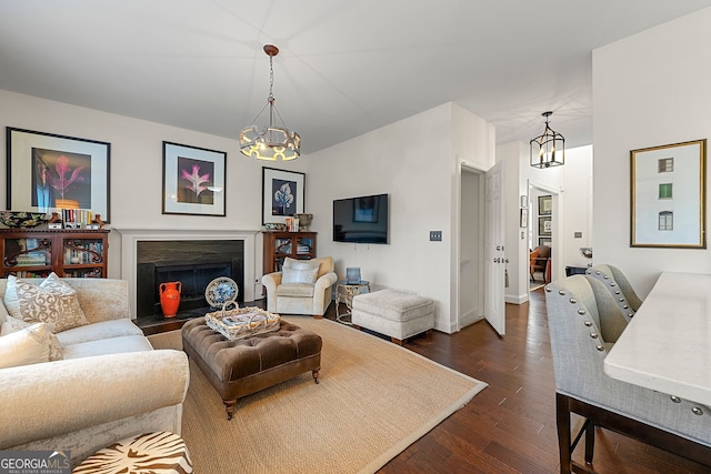 living room with dark wood-type flooring and a notable chandelier