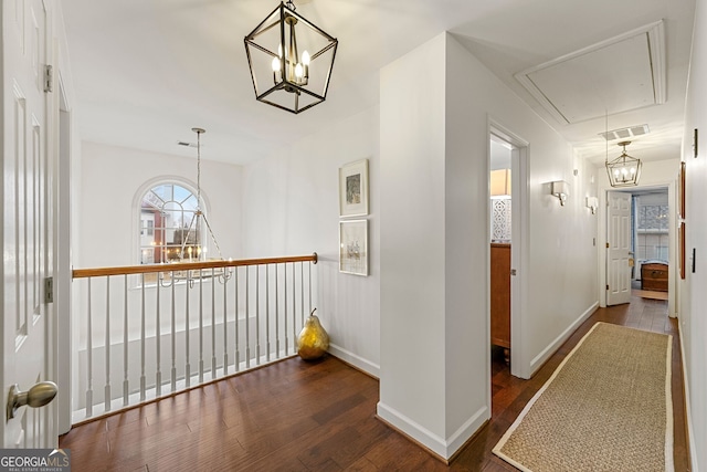 hall featuring dark hardwood / wood-style floors and a chandelier