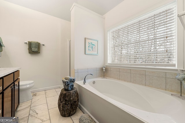 bathroom featuring vanity, a tub to relax in, and toilet