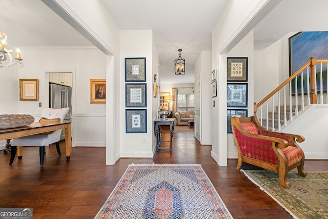 foyer entrance with crown molding, dark hardwood / wood-style floors, and a chandelier