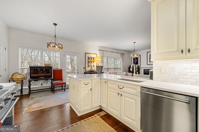 kitchen with stainless steel appliances, sink, decorative light fixtures, and kitchen peninsula