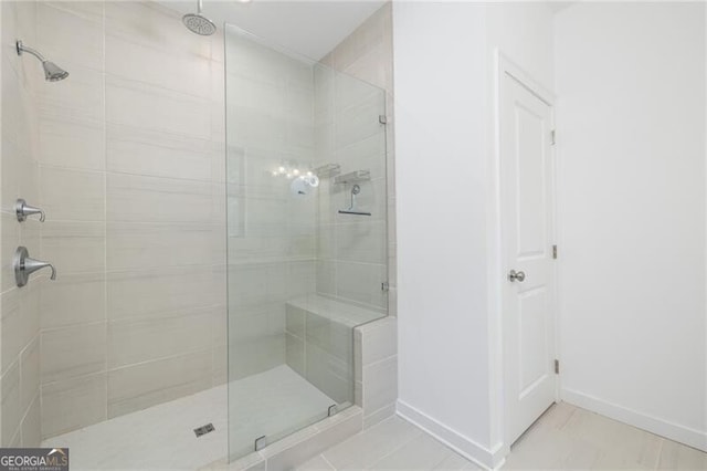 bathroom with tile patterned flooring and a tile shower