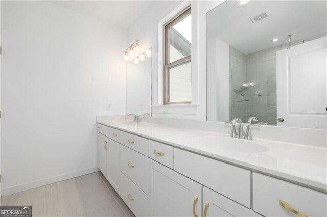 bathroom featuring vanity, a wealth of natural light, and a shower with door