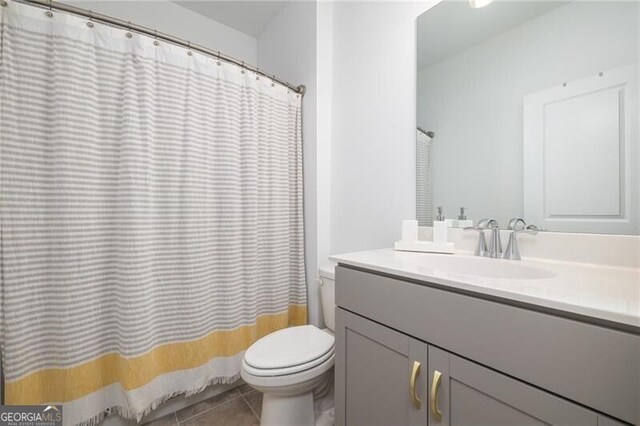 bathroom featuring tile patterned flooring, vanity, and toilet