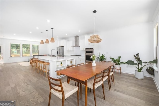 dining area featuring sink and light hardwood / wood-style floors