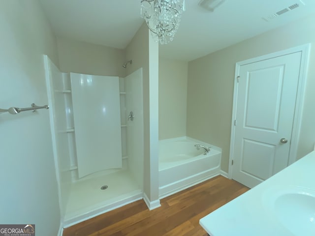 bathroom with hardwood / wood-style flooring, plus walk in shower, sink, and a notable chandelier