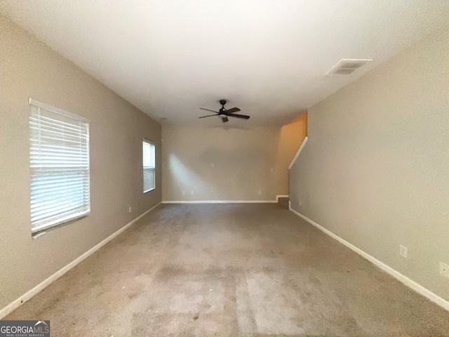 carpeted spare room featuring ceiling fan