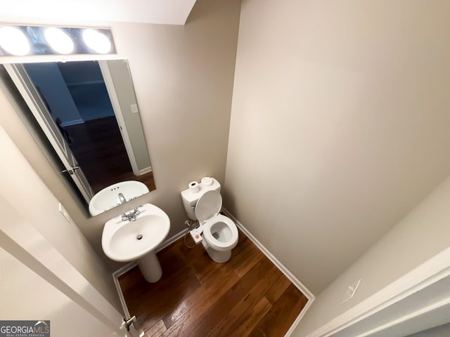 bathroom with hardwood / wood-style flooring, toilet, and sink