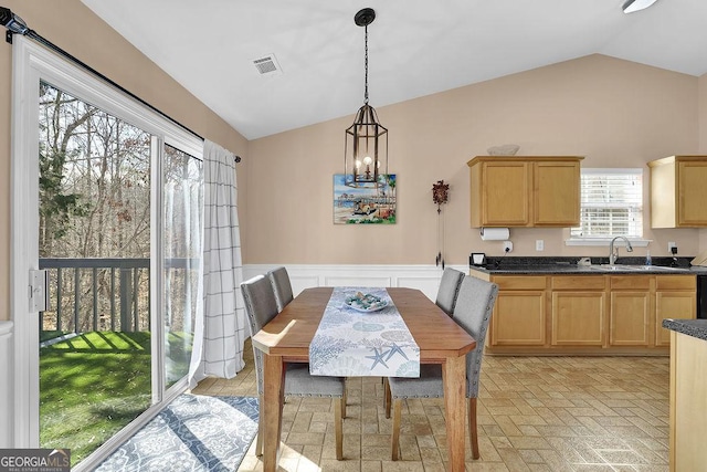 dining area with sink and vaulted ceiling