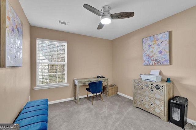 carpeted home office featuring ceiling fan