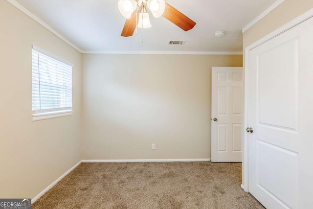 empty room with light carpet, crown molding, and ceiling fan