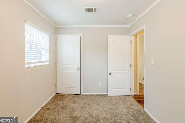 unfurnished bedroom with crown molding and light colored carpet