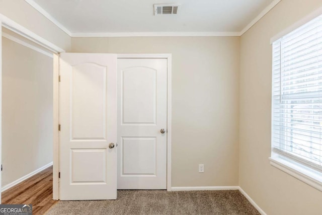 unfurnished bedroom featuring ornamental molding and light carpet