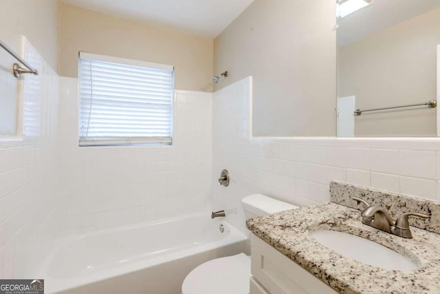 full bathroom featuring vanity, tile walls, toilet, and tiled shower / bath