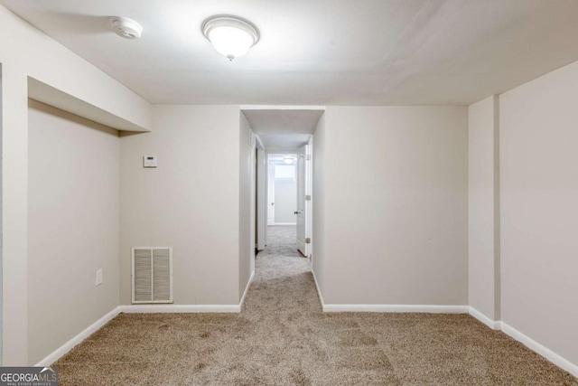 unfurnished room featuring light carpet