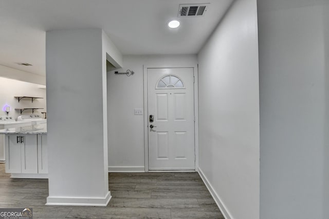 entryway with wood-type flooring and washing machine and dryer