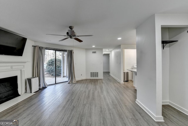 unfurnished living room with ceiling fan and light wood-type flooring