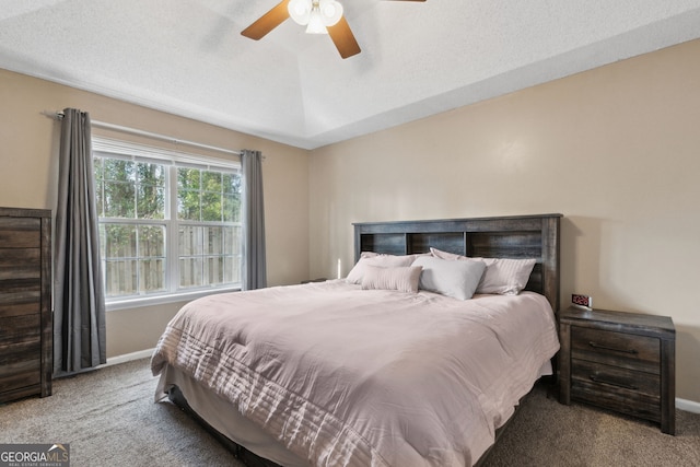 bedroom with ceiling fan, carpet floors, and a textured ceiling