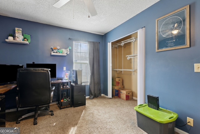 carpeted home office with ceiling fan and a textured ceiling