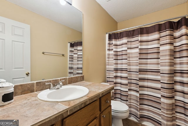 bathroom featuring vanity, toilet, and a textured ceiling