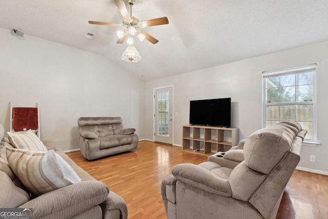 living room with hardwood / wood-style flooring, ceiling fan, and vaulted ceiling