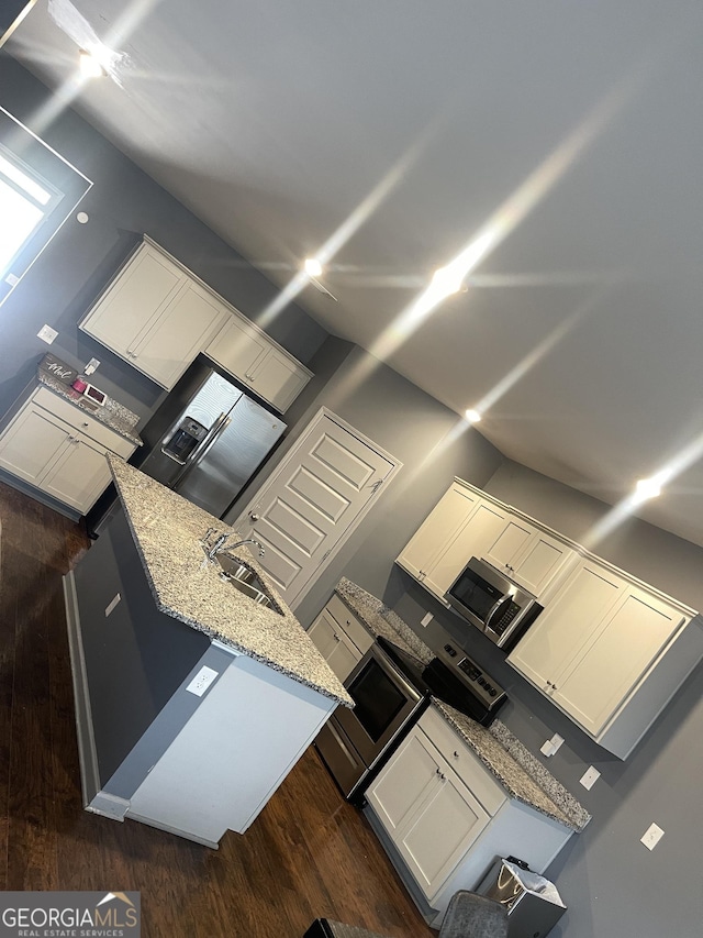 kitchen featuring white cabinetry, sink, light stone counters, and dark wood-type flooring