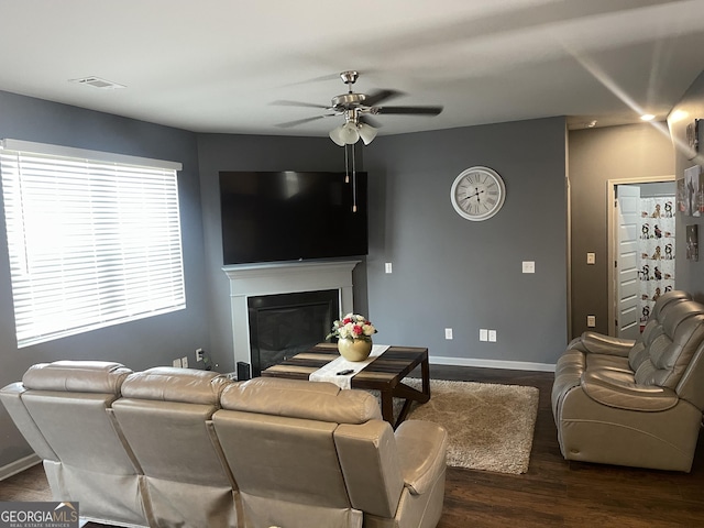 living room featuring dark wood-type flooring and ceiling fan