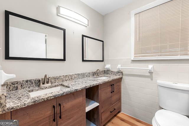 bathroom with hardwood / wood-style floors, vanity, tile walls, and toilet