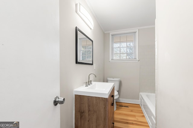 bathroom with vanity, hardwood / wood-style floors, crown molding, and toilet