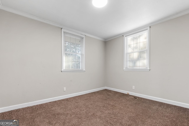 empty room featuring crown molding and carpet