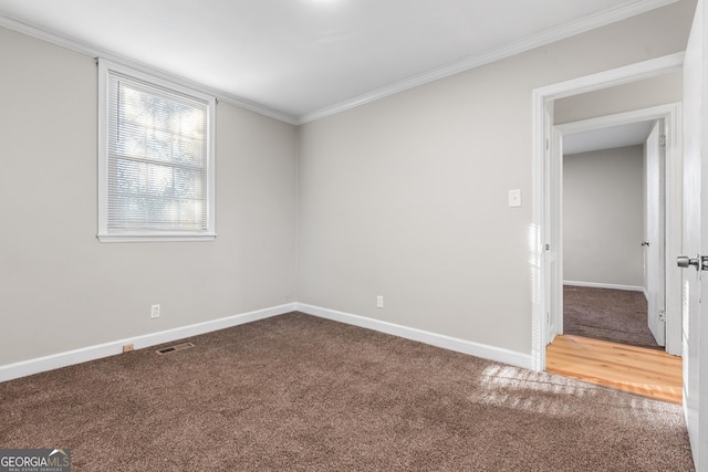 spare room featuring ornamental molding and carpet