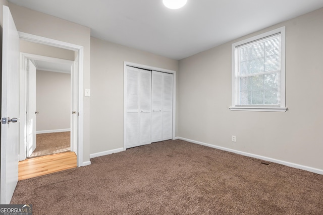 unfurnished bedroom featuring a closet and carpet flooring