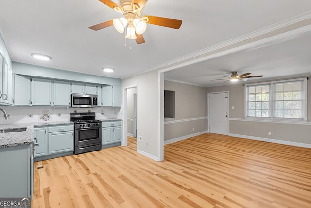 kitchen featuring sink, crown molding, light wood-type flooring, and appliances with stainless steel finishes