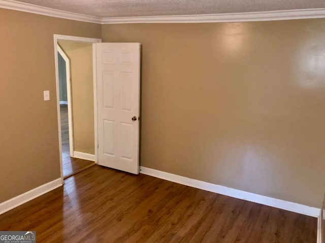 empty room with dark wood-type flooring, ornamental molding, and a textured ceiling