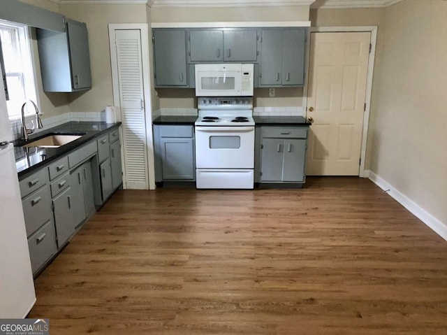 kitchen featuring sink, white appliances, crown molding, gray cabinetry, and dark hardwood / wood-style flooring