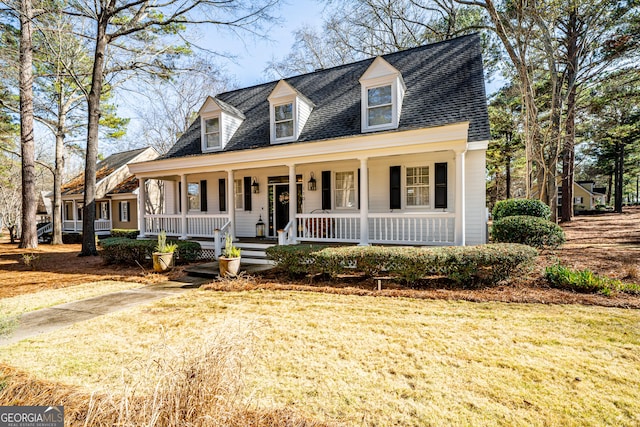 cape cod-style house with covered porch and a front yard