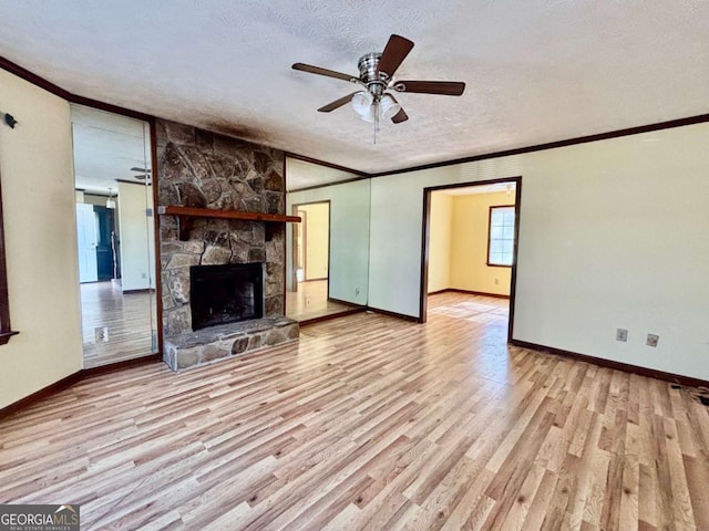 unfurnished living room featuring crown molding, a fireplace, a textured ceiling, and light hardwood / wood-style floors