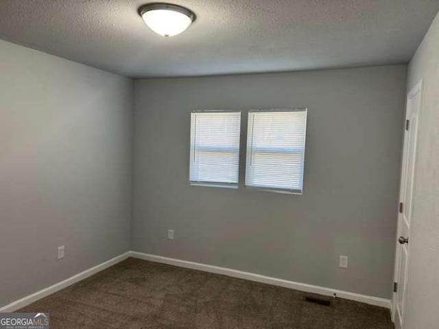 carpeted spare room featuring a textured ceiling