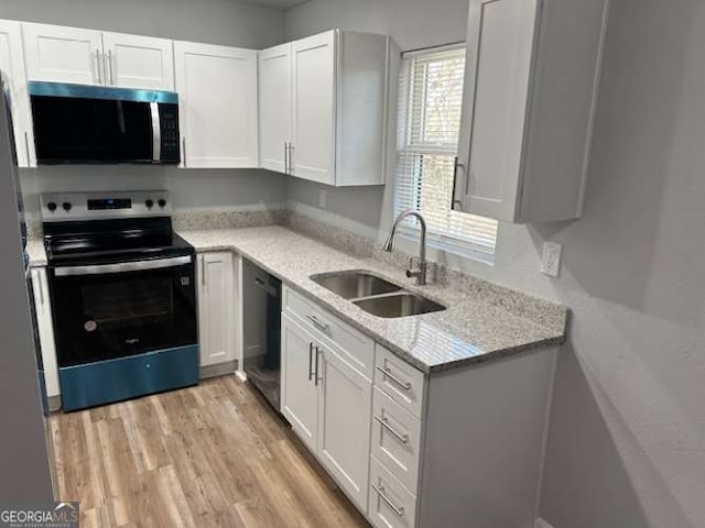 kitchen featuring white cabinetry, range with electric cooktop, sink, and light stone counters