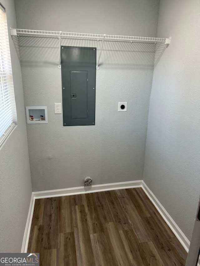 clothes washing area featuring dark hardwood / wood-style floors, hookup for an electric dryer, electric panel, and hookup for a washing machine