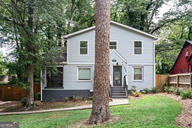1574 Mayflower St, Atlanta, GA 30311 - traditional-style home featuring brick siding, a front lawn, and fence