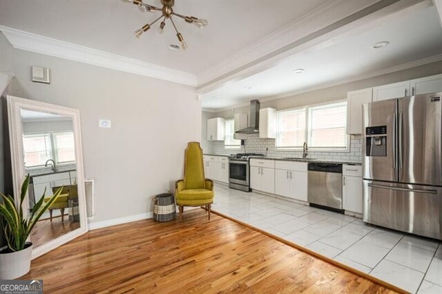 1574 Mayflower St, Atlanta, GA 30311 - kitchen with a sink, appliances with stainless steel finishes, backsplash, wall chimney exhaust hood, and a notable chandelier