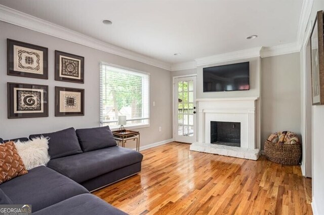 1574 Mayflower St, Atlanta, GA 30311 - living area with light wood-type flooring, baseboards, a fireplace with raised hearth, and crown molding