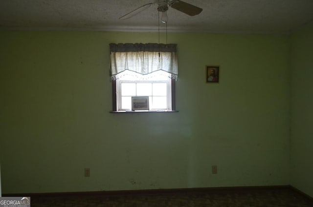 unfurnished room with ceiling fan and a textured ceiling