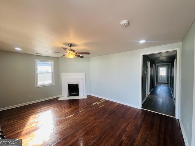 unfurnished living room featuring ceiling fan and dark hardwood / wood-style flooring